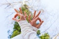 Close up woman hand in yoga mudra gesture from below view to the sky and tree