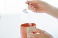 Close up of woman hands adding sugar to tea cup Royalty Free Stock Photo