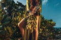 Close up of woman hands with boho accessories holding a bunch of banans Royalty Free Stock Photo