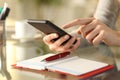 Woman checking phone with agenda over the table