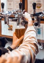 Close up of woman hands filling plastic bottle of craft beer in bulk Royalty Free Stock Photo