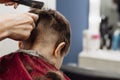 Close-up of woman hands grooming kid boy hair in barber shop. Royalty Free Stock Photo