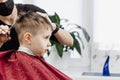 Close-up of woman hands grooming kid boy hair in barber shop Royalty Free Stock Photo