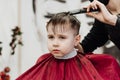 Close-up of woman hands grooming kid boy hair in barber shop Royalty Free Stock Photo