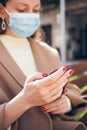 Close up of woman hands holding cellphone and waiting for a taxi, tracking the arrival of a car using her smartphone while sitting Royalty Free Stock Photo