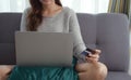 Close up of woman hands holding credit card and laptop. Young woman paying online using banking entering data shopping order in Royalty Free Stock Photo