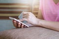 Close up woman hands holding credit card and using cell phone for online shopping on sofa in the living room of the house. Royalty Free Stock Photo