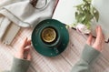 Close up of woman hands holding a cup of lemon tea on table in a winter afternoon. Woman hands holding hot drink on table. Royalty Free Stock Photo