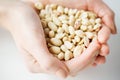 Close up of woman hands holding peeled peanuts