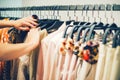 Close up woman hands make choice on colorful clothes on racks in a fashion boutique Royalty Free Stock Photo