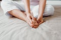 Close-Up of Woman Hands is Massaging Her Feet on Bedroom, Young Adult having Legs Ache After Home Work. Healthcare and Medicine Royalty Free Stock Photo