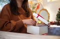 Close-up woman hands opening white gift box with Christmas home decoration on the background Royalty Free Stock Photo