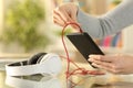 Woman hands plugging headphones to smart phone Royalty Free Stock Photo