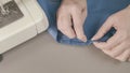 Close-up of woman hands sewing a button. The dressmaker sews a button on a clothes Royalty Free Stock Photo