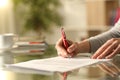 Woman signing document with pen on a desk at home Royalty Free Stock Photo