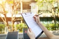 Close up of woman hands signing rental agreement sunny day condo back. Front used with Open Font License