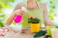 Close up of woman hands spraying roses in pot