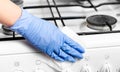 Close-up of woman hands with surgical gloves cleaning the coocking stove of grease and dirt