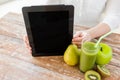 Close up of woman hands tablet pc and fruit juice Royalty Free Stock Photo