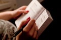 Close-up of a woman hands taking notes in a book while studying at home