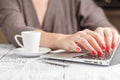 Close up of a woman hands typing in a laptop in a coffee shop te Royalty Free Stock Photo