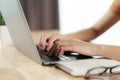 Close up of woman hands typing on laptop keyboard on wooden table at home office or workplace Royalty Free Stock Photo