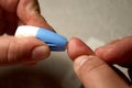 Close up of woman hands using lancet on finger to check HIV status. Blue lancet. Hiv test express Royalty Free Stock Photo