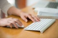 Close up of woman hands using mouse and keyboard.