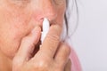 Close up of woman hands using nasal spray Royalty Free Stock Photo