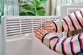 Close-up of woman hands warming near electric heating radiator Royalty Free Stock Photo