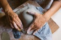 Close up of woman hands working clay making pottery at home. Concept of hobby and creativity at home. Kneading and moistening the Royalty Free Stock Photo