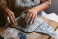 Close up of woman hands working clay making pottery at home. Concept of hobby and creativity at home. Kneading and moistening the Royalty Free Stock Photo