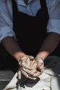 Close up of woman hands works with clay. Female potter kneads and moistens the clay before work. Royalty Free Stock Photo
