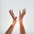 Close up of woman hands wrapped in New Year`s light. Gesture of getting ready for New Years eve.