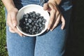 Close up of a woman holding a bowl of blueberries