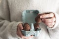 Close up of woman holding easter chocolate egg from egg carton Royalty Free Stock Photo