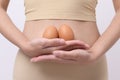 Close up woman holding eggs on belly , prepare reproductive fertility , Ovulation stimulation , matherinty concept Royalty Free Stock Photo