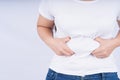 Close-up woman holding excessive belly fat, overweight abdomen on white background. Weight loss, diet lifestyle, healthy concept Royalty Free Stock Photo