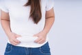 Close-up woman holding excessive belly fat, overweight abdomen on white background. Weight loss, diet lifestyle, healthy concept Royalty Free Stock Photo