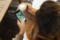 Close-up woman holding new iphone 7 showing app screen in coffee shop