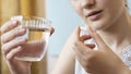 Close up woman holding pill in hand with water. Female going to take tablet from headache, painkiller, medication drinking clear w Royalty Free Stock Photo