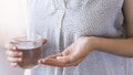 Close up woman holding pill in hand with water. Female going to take tablet from headache, painkiller, medication drinking clear w Royalty Free Stock Photo