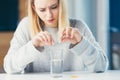 Close up of woman holding pills and glass of fresh water, taking medicine for headache, abdominal pain or taking vitamins, healthc Royalty Free Stock Photo