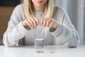 Close up of woman holding pills and glass of fresh water, taking medicine for headache, abdominal pain or taking vitamins, healthc Royalty Free Stock Photo
