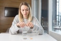 Close up of woman holding pills and glass of fresh water, taking medicine for headache, abdominal pain or taking vitamins, healthc Royalty Free Stock Photo