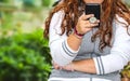 Close-up of woman holding and reading from a cell phone in black case with grip handle on back  - long hair with cute bracelets Royalty Free Stock Photo