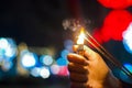 Close up of woman holding sparkler on the street. Closeup of Girl with Sparkle . Close up of woman holding sparkler on the street