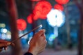 Close up of woman holding sparkler on the street. Closeup of Girl with Sparkle.