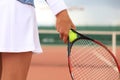 Close up of woman is holding tennis racket on hard tennis court. Tennis ball in player hand Royalty Free Stock Photo