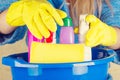 Close-up of woman holdinh basin with cleaning supplies